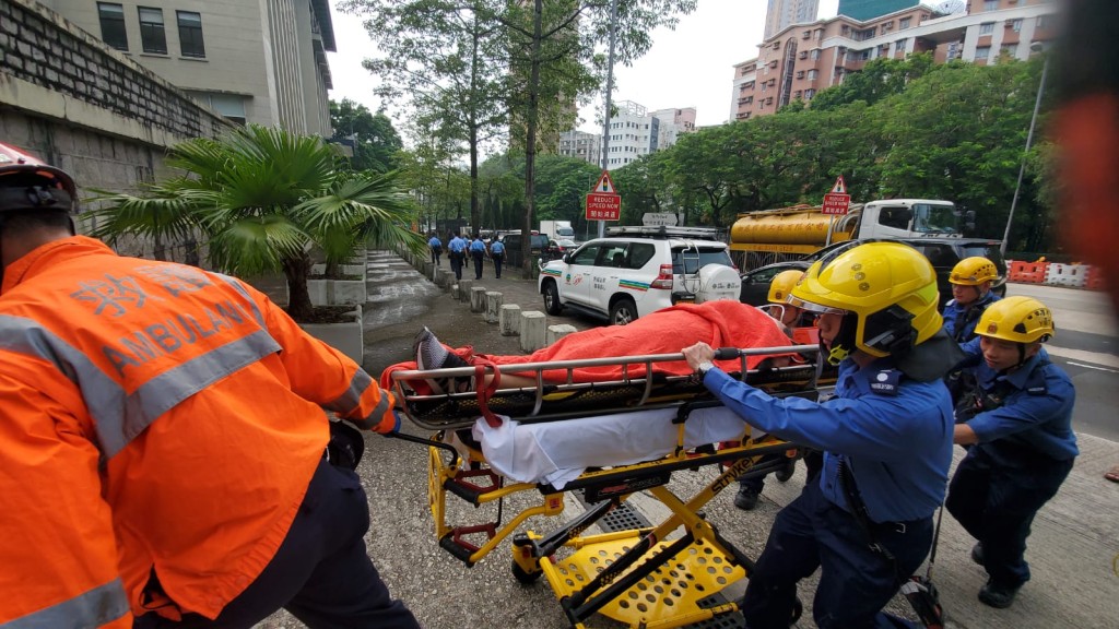 救護員將傷者抬下山送院。歐陽偉光攝