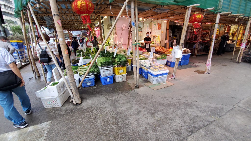 菜檔將蔬菜搬出店外售賣。