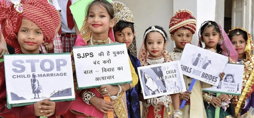 一班印度兒童舉着「拒絕童婚」的標語。