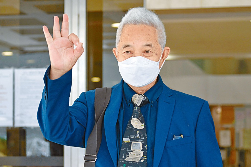 郭卓堅步出法院時,向傳媒舉起「OK」手勢。