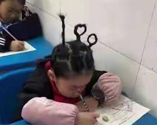 湖南小學生扎100分辮子參加期末考。