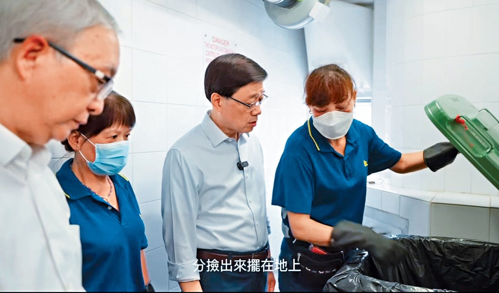 特首李家超在五一勞動節到訪垃圾收費試點連翠邨，了解清潔工友在試點計劃推行後的工作情況。