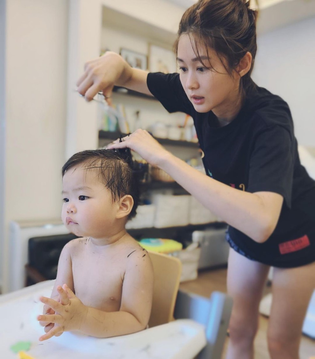 岑丽香为儿子剪发。