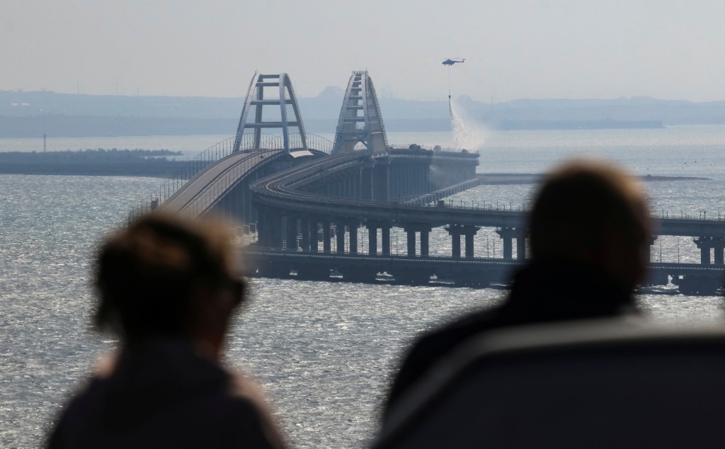 大橋上空大火竄起數米高，多節車廂瀰漫濃煙，橋面崩塌掉入海中。。路透社圖片