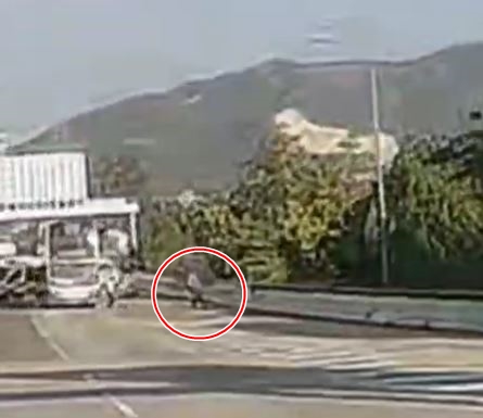 交通警員走至路肩位置避開衝至的巴士。(影片頻道「沿圖有理」提供)  ​​ 