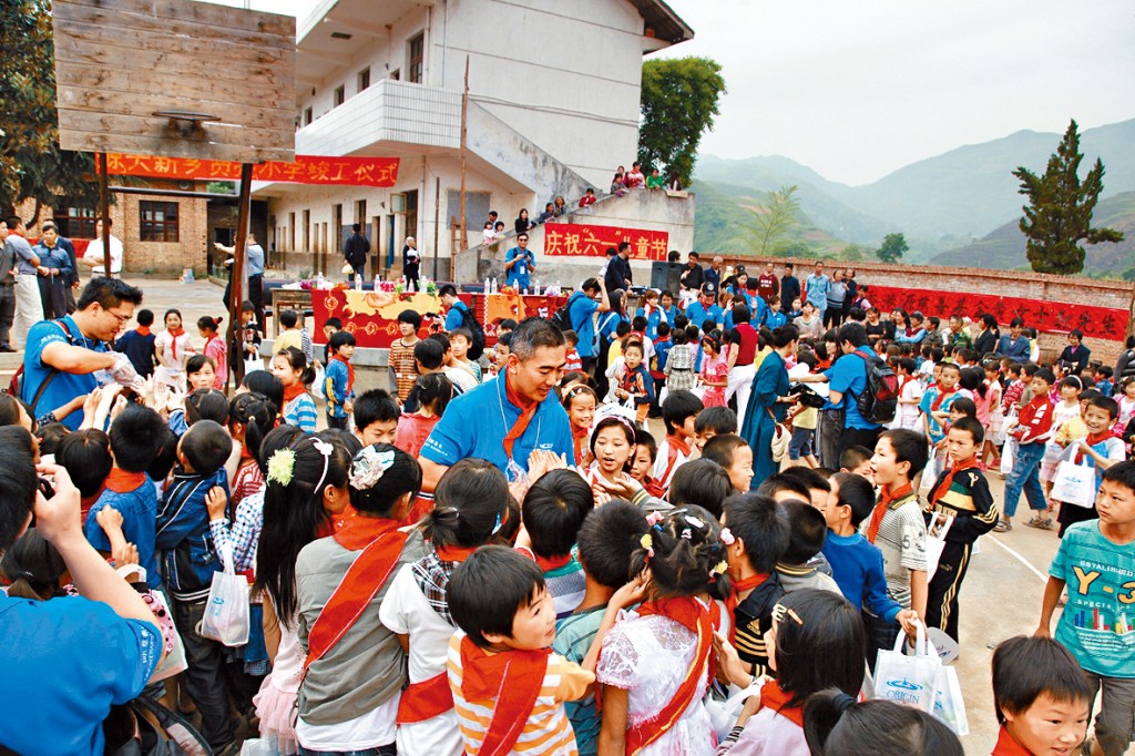 郭永亮喺同太太黃兆賢共同捐建嘅湖南大新鄉賢亮小學義教，跟小朋友打成一片。