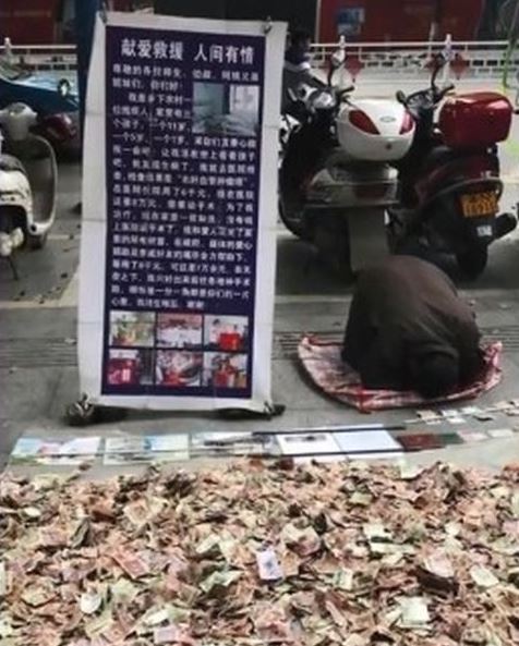 男子身旁豎有一塊寫有「獻愛救援,人間有情」的牌。