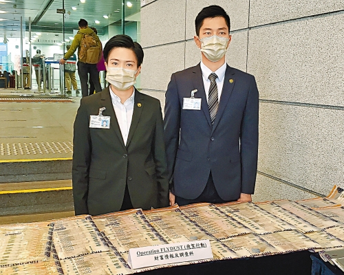 總督察鄧凱彤（左）及高級督察楊展榮（右）展示檢獲的現鈔等證物。