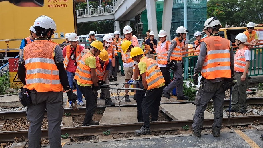 維修工人在鍾屋村站 行人過路線 重鋪石屎板。