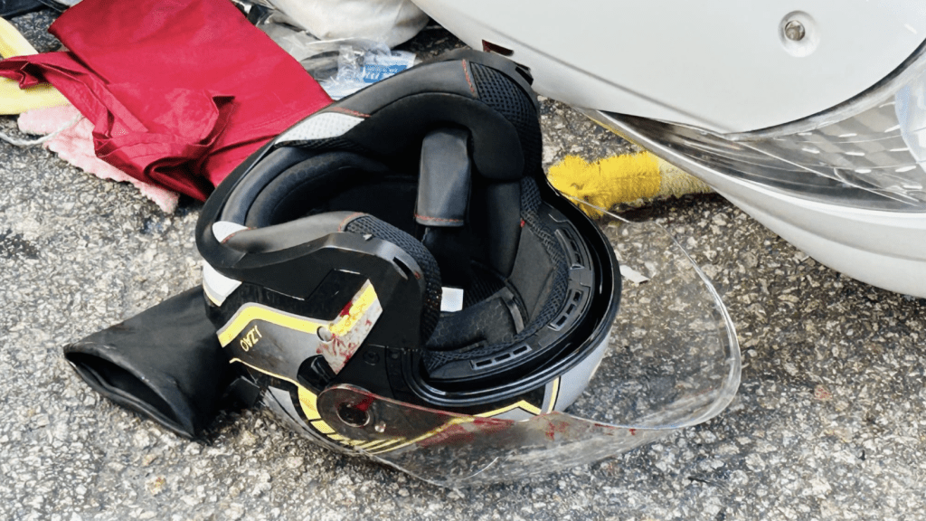 電單車倒在的士面前,地上遺下一個染血頭盔。蔡楚輝攝 電單車倒在的士面前,地上遺下一個染血頭盔。蔡楚輝攝