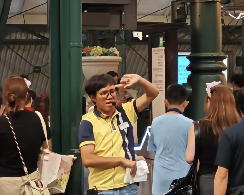 一名香港迪士尼站港鐵職員因以英語、粵語及普通話「Rap式」播報分流指引。影片擷圖 一名香港迪士尼站港鐵職員因以英語、粵語及普通話「Rap式」播報分流指引。影片擷圖