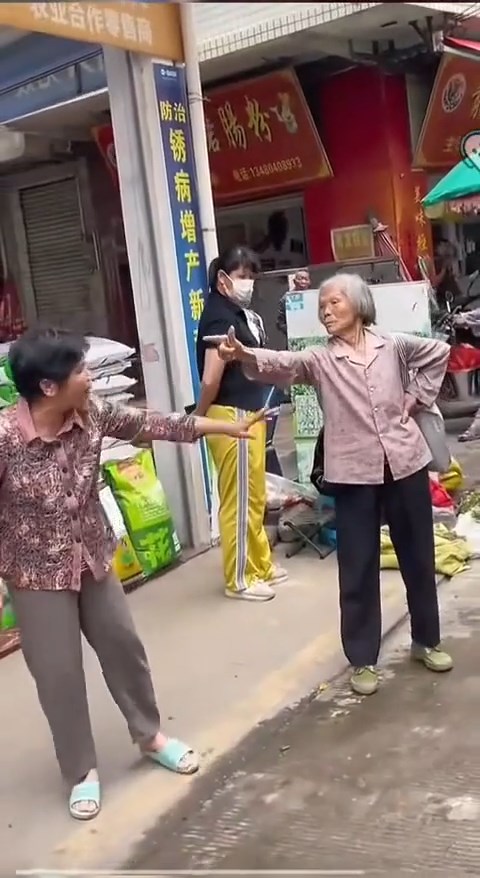 白发老妇与邻人起争执时，连续6次摆出“开枪”手势。抖音@月亮好物分享
