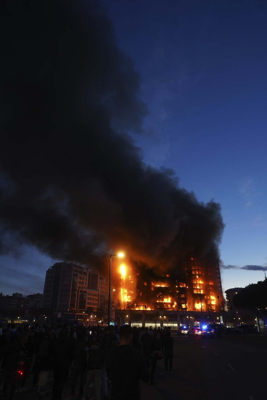建筑物的整个正面都著火，燃烧的碎片掉落到行人道。美联社