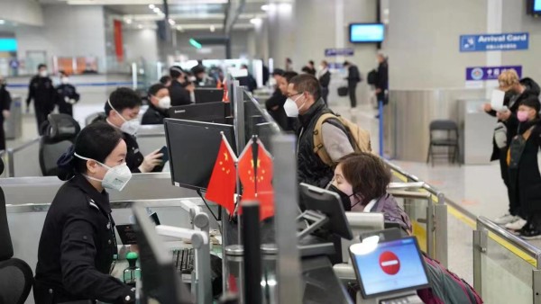 節日期間上海移民管理警察為旅客辦理邊檢通關手續。