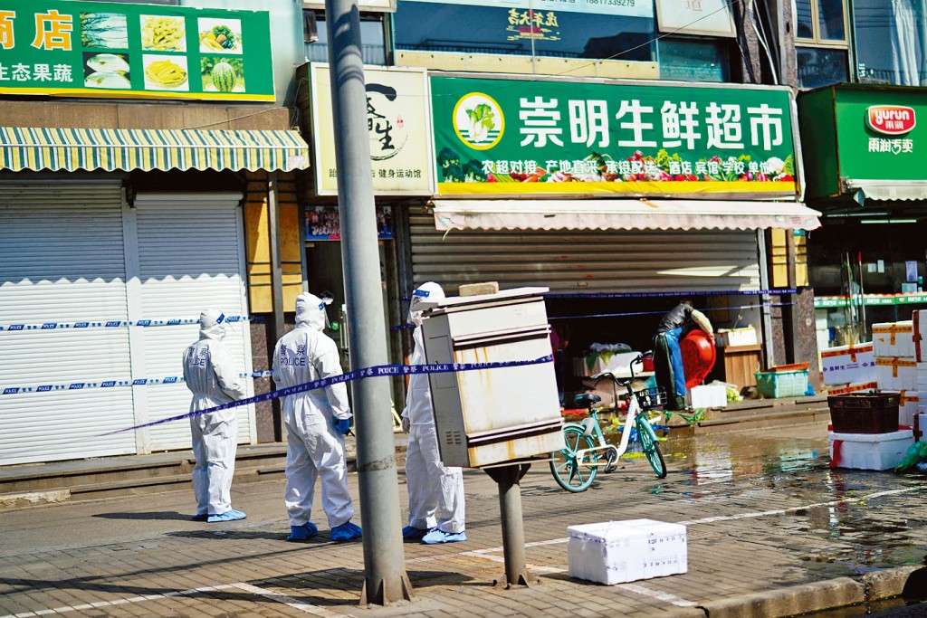 身穿防護服的上海警員在街上巡邏。