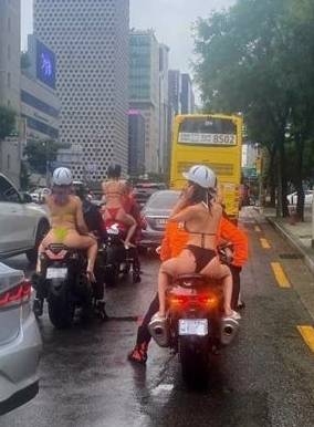 多名身穿比坚尼的女子坐著电单车后坐，穿梭南韩闹市。(互联网)