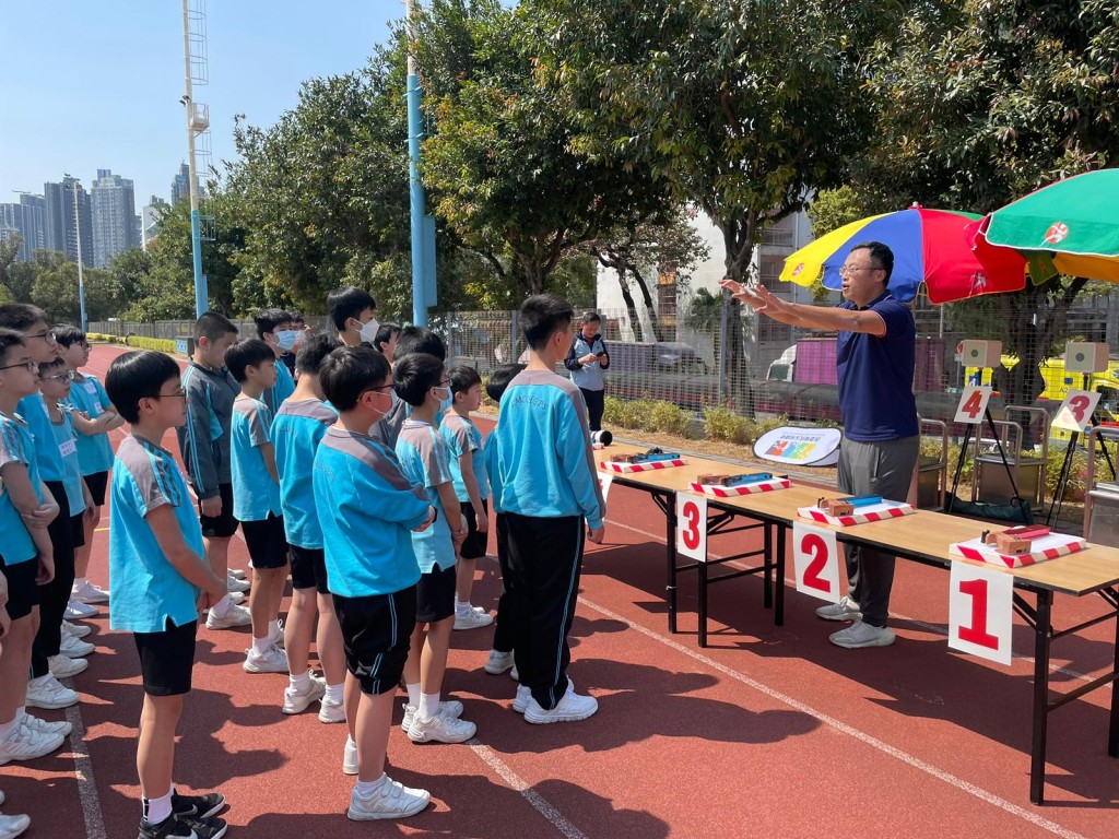 香港现代五项总会副秘书长朱江(右)向学生讲解比赛规则。秀茂坪少年警讯图片