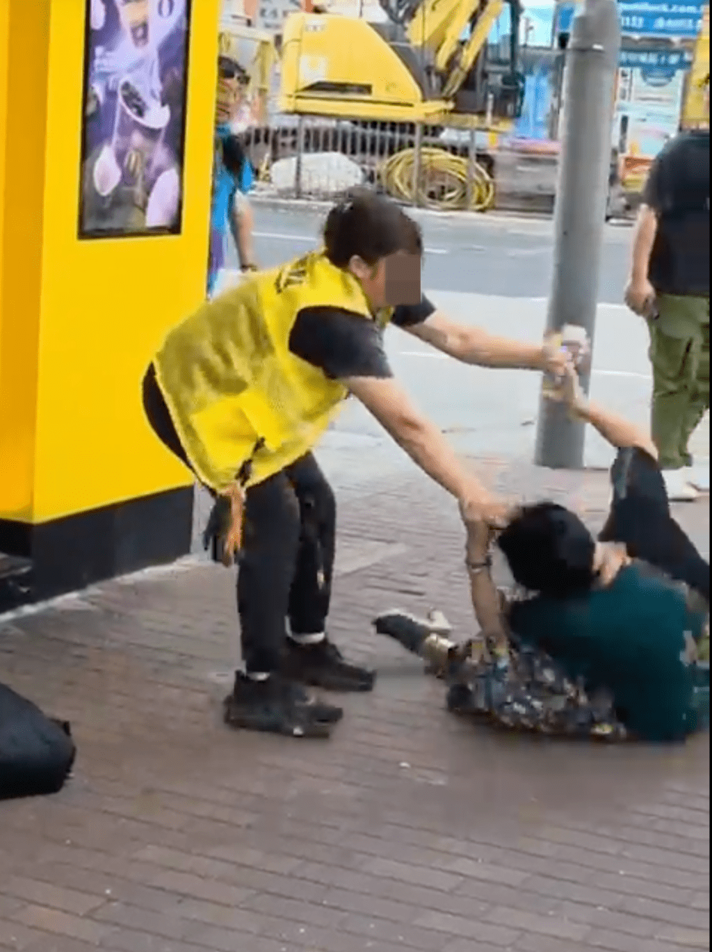 身穿黃色背心女子上前動手，抓住對方頭髮並將其扯跌在地。Threads@okkelvin 影片截圖