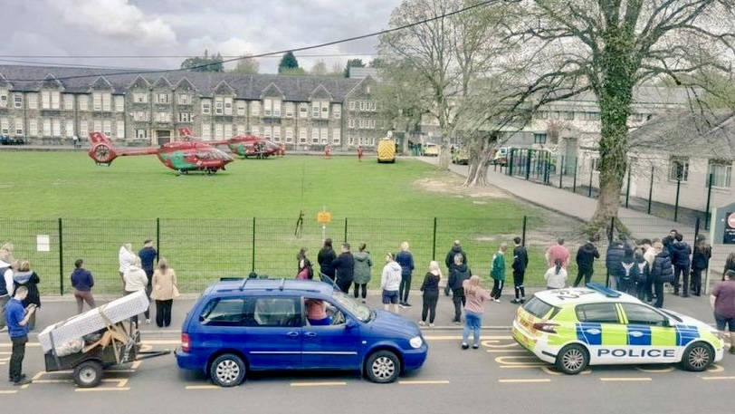 網傳照片顯示緊急服服直升機停在學校草坪，家長在圍欄外焦急等候。 X