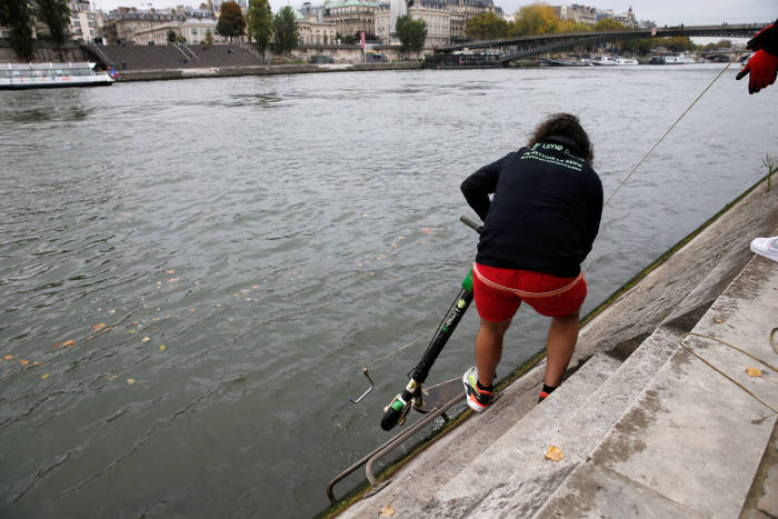 巴黎Lime職員從塞納河「釣」出被棄置的滑板車。 資料圖片