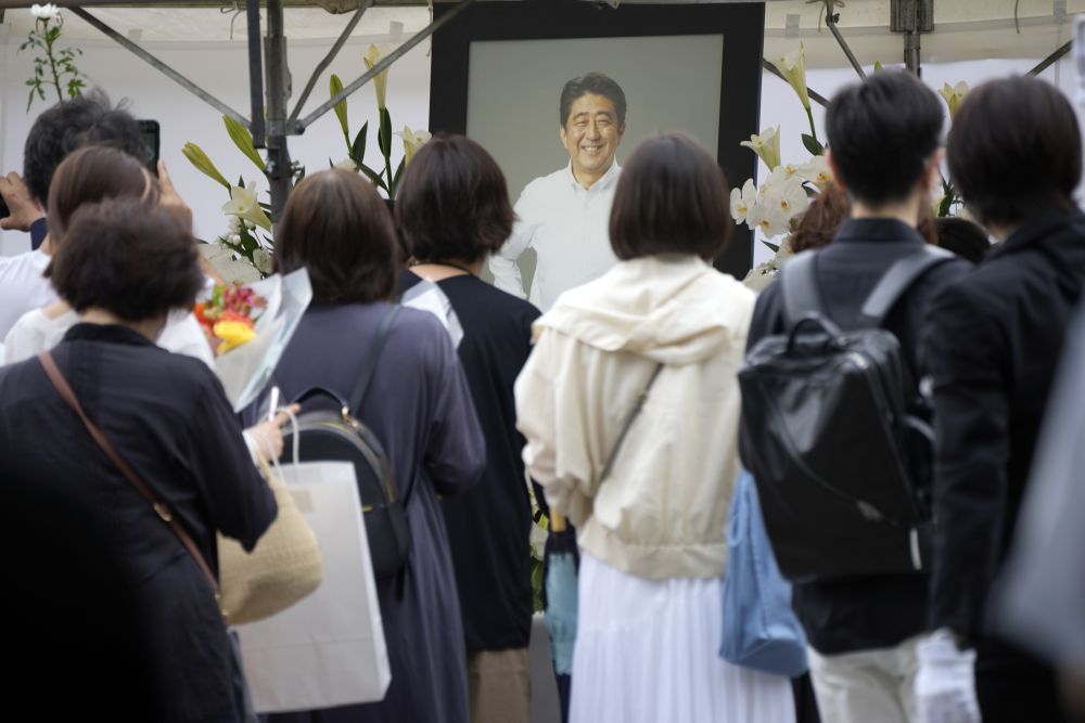 日本民众在增上寺前为安倍晋三献花和祈祷。AP图