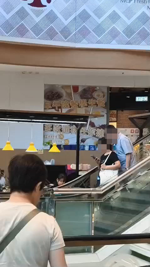 一名男子搭扶手梯時偷聞前方女子的「髮香」。網上片段截圖 一名男子搭扶手梯時偷聞前方女子的「髮香」。網上片段截圖