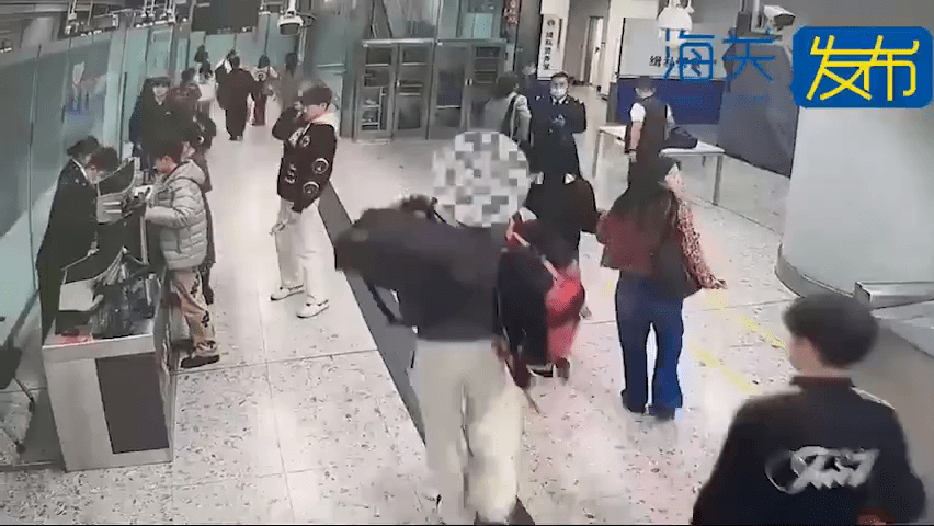 男旅客大包小包的走過海關監管區。