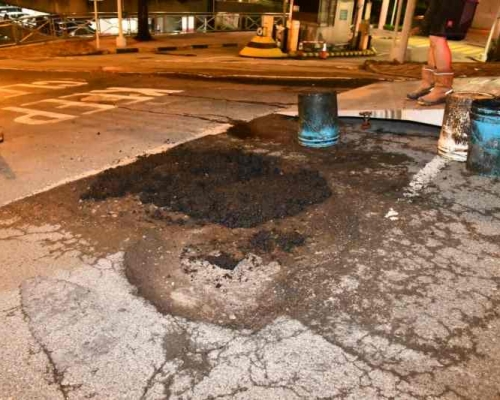 事後修路工人用瀝青將路陷鋪平。丁志雄攝