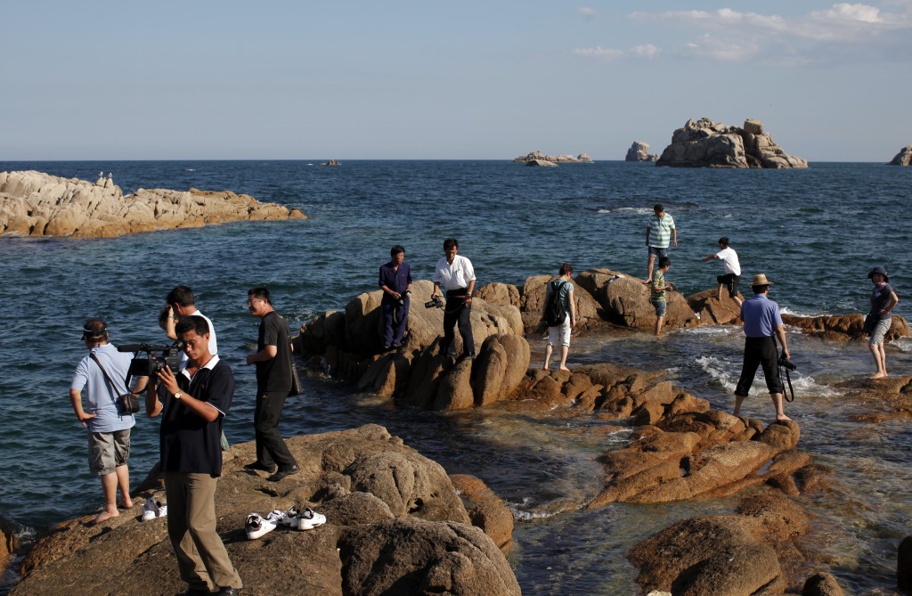 2011年中国旅游代表团成员参观金刚山旅游区的海滩。 路透社