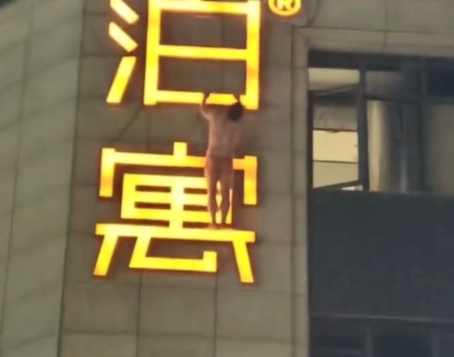 男子雙手抓住廣告牌。微博