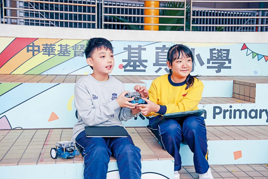 （左起）五年級學生謝泊熹和陳玥晴認為，mBot製作過程最大的收穫是學會堅持不放棄。