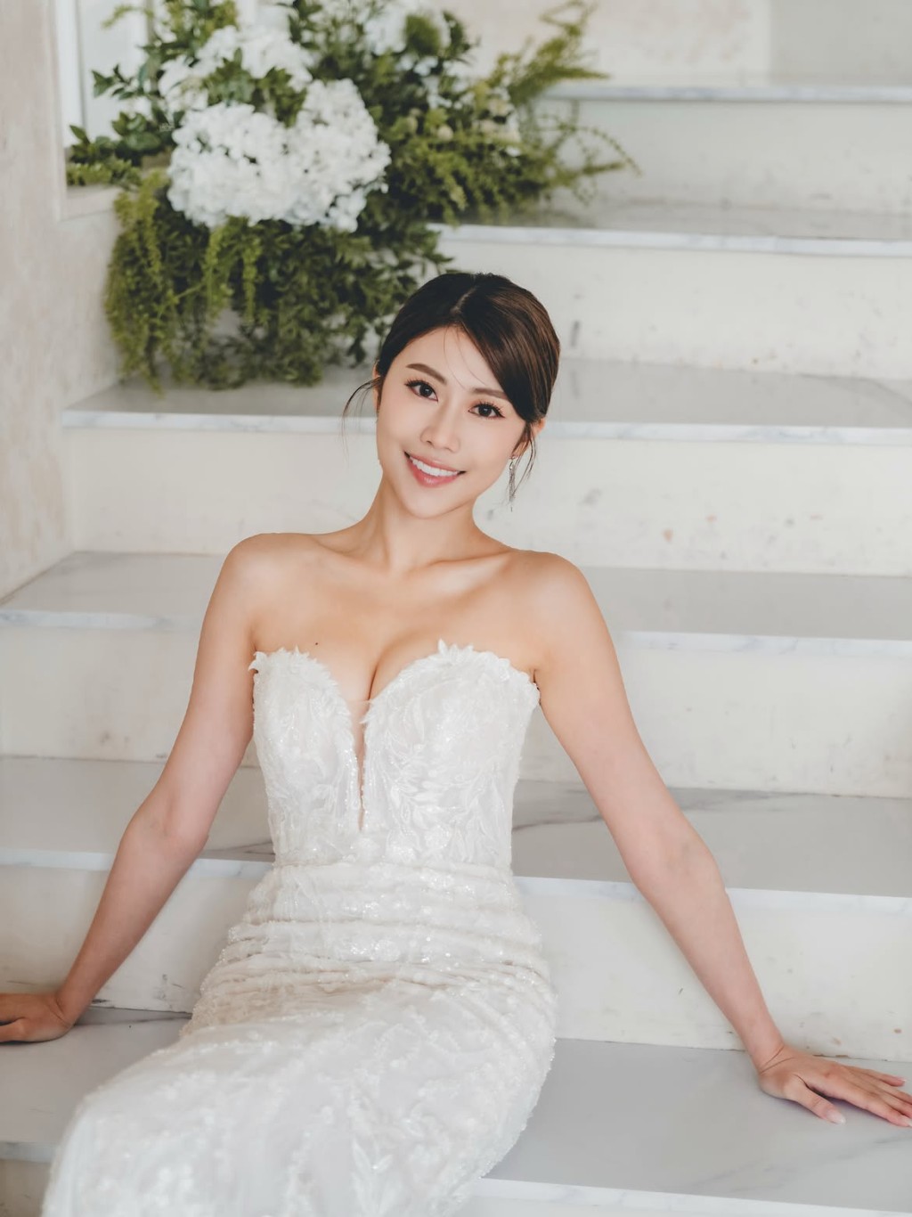 鍾翠詩坐在白色階梯背景前，散發女神氣場。 