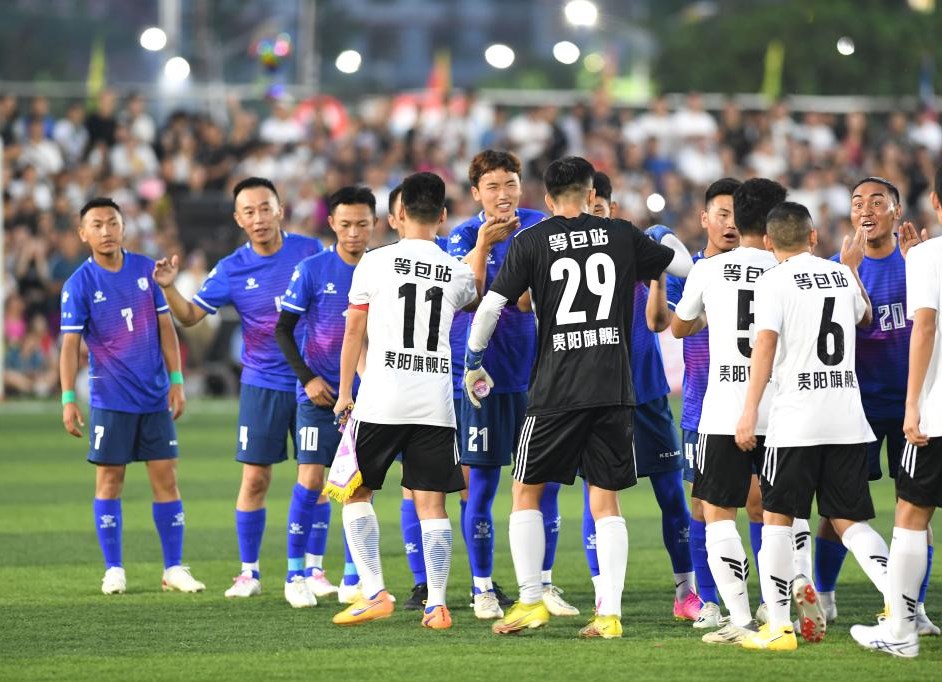 6月23日，贵州省榕江县足球队球员（前）与青海省果洛州格萨尔王足球队在友谊赛前击掌致意。新华社