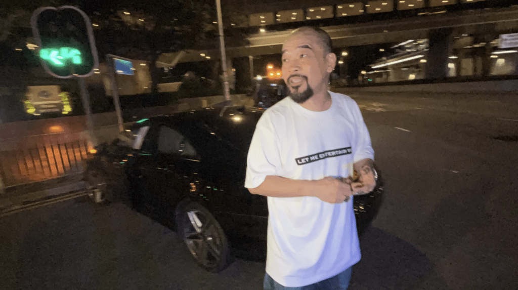 車禍後，身穿T恤牛仔褲的葛民輝自行步出車廂，並無受傷。蔡楚輝攝