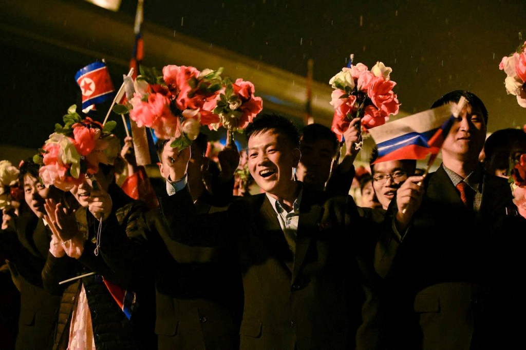 北韓民眾手持鮮花和兩國國旗，歡迎拉夫羅夫到訪。路透社