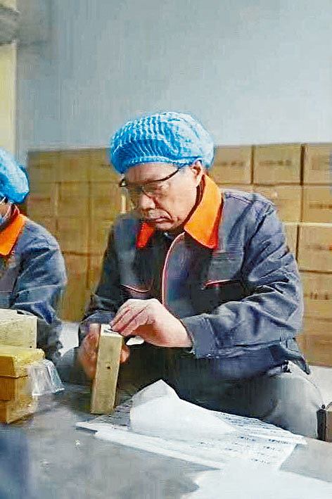 任志強身穿囚衣，和其他獄友一同做木工。