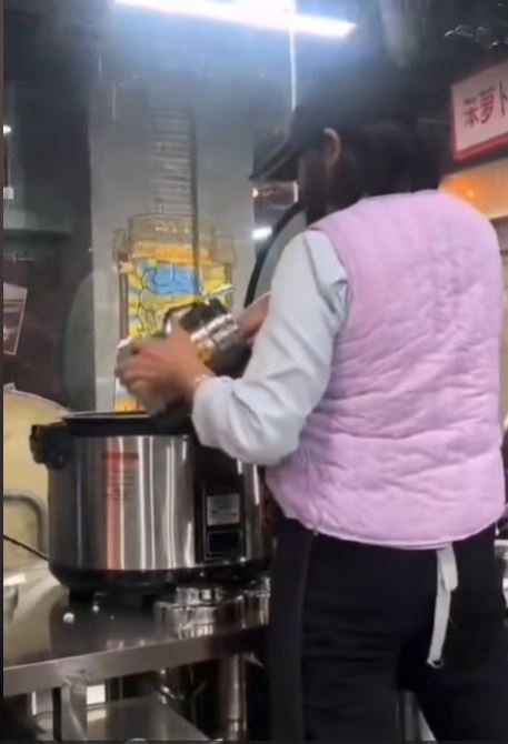 深圳有食店员工将食客吃剩的米饭回收到电饭煲，准备再盛予新客人。影片截图