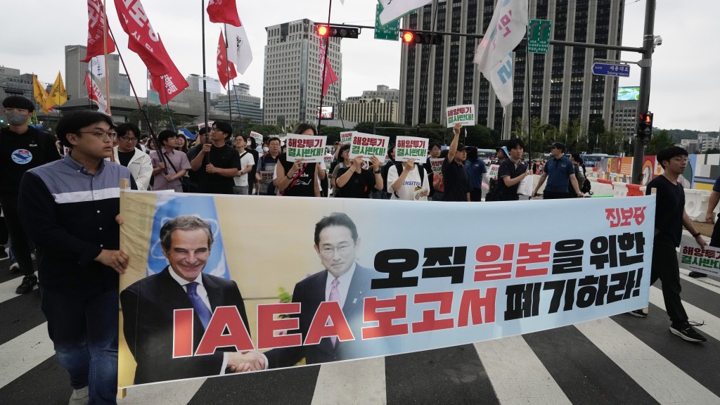 南韩示威者针对IAEA总干事格罗西和日本首相岸田文雄，游行抗议日本核污水排海。 美联社