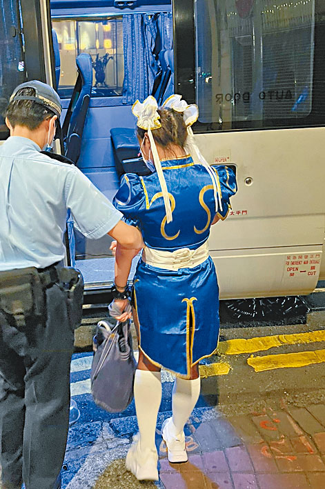 被捕女子由警員帶署調查。