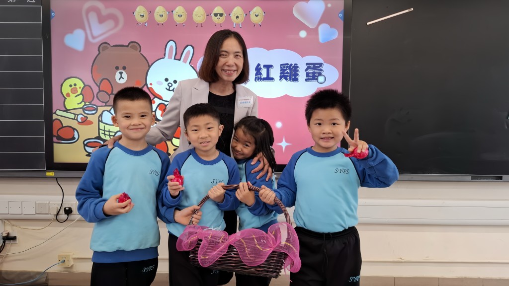 小一100日活動，學校向學生送贈紅雞蛋；後方為香港道教聯合會純陽小學蔡華媚校長。（圖片來源：受訪者提供）