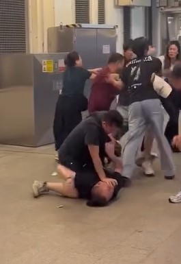 有兩男纏鬥「地面戰」，一人把對方壓頸、按在地上揮拳。