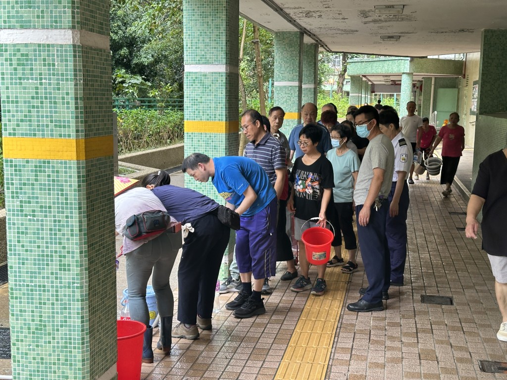 20多名居民排队取食水。梁国峰摄