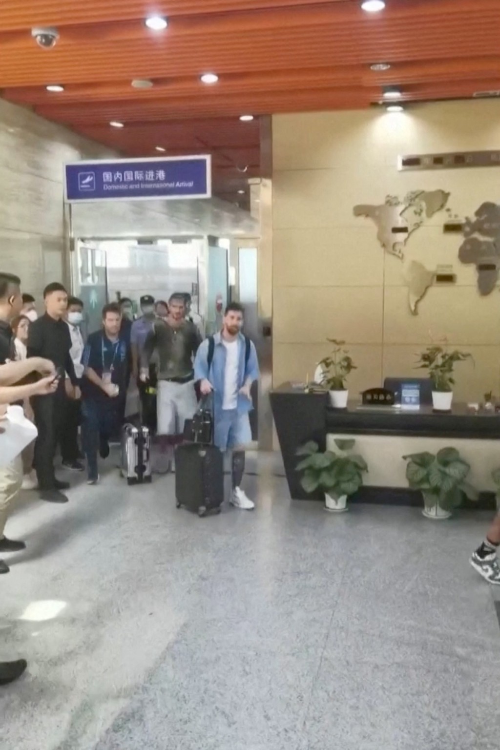 美斯抵达北京时，在机场向为他欢呼的粉丝挥手致意。网片截图