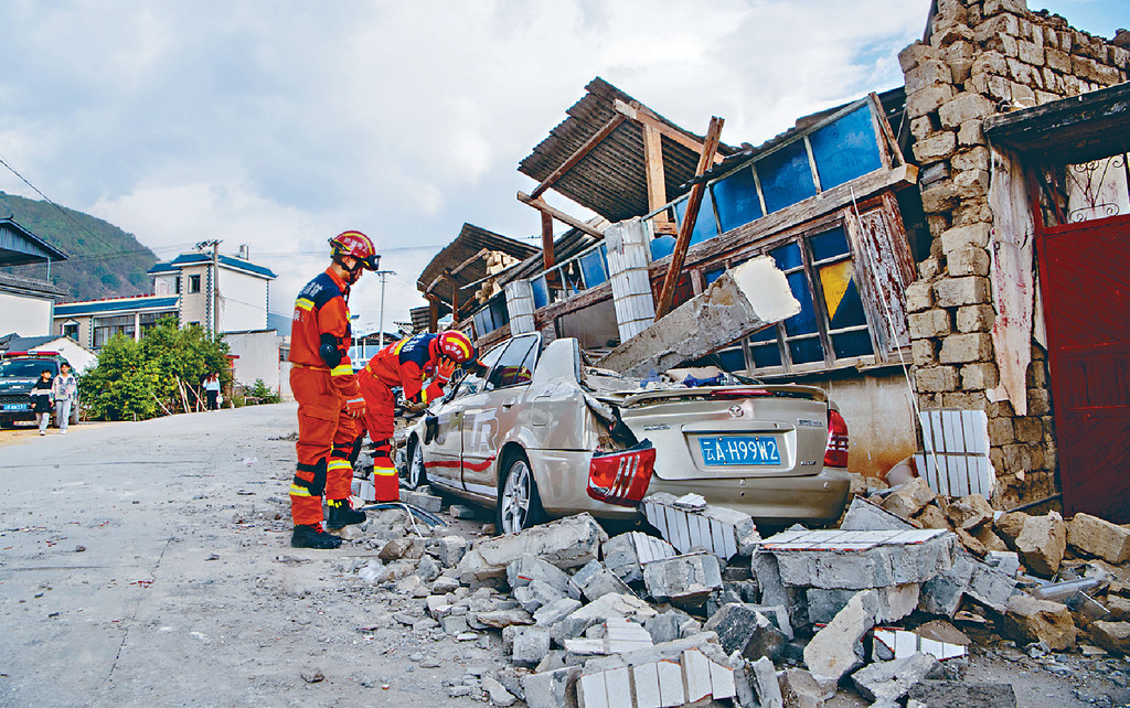 ■救援人員在雲南省保山市隆陽區瓦窯鎮排查受損的房屋和車輛。
