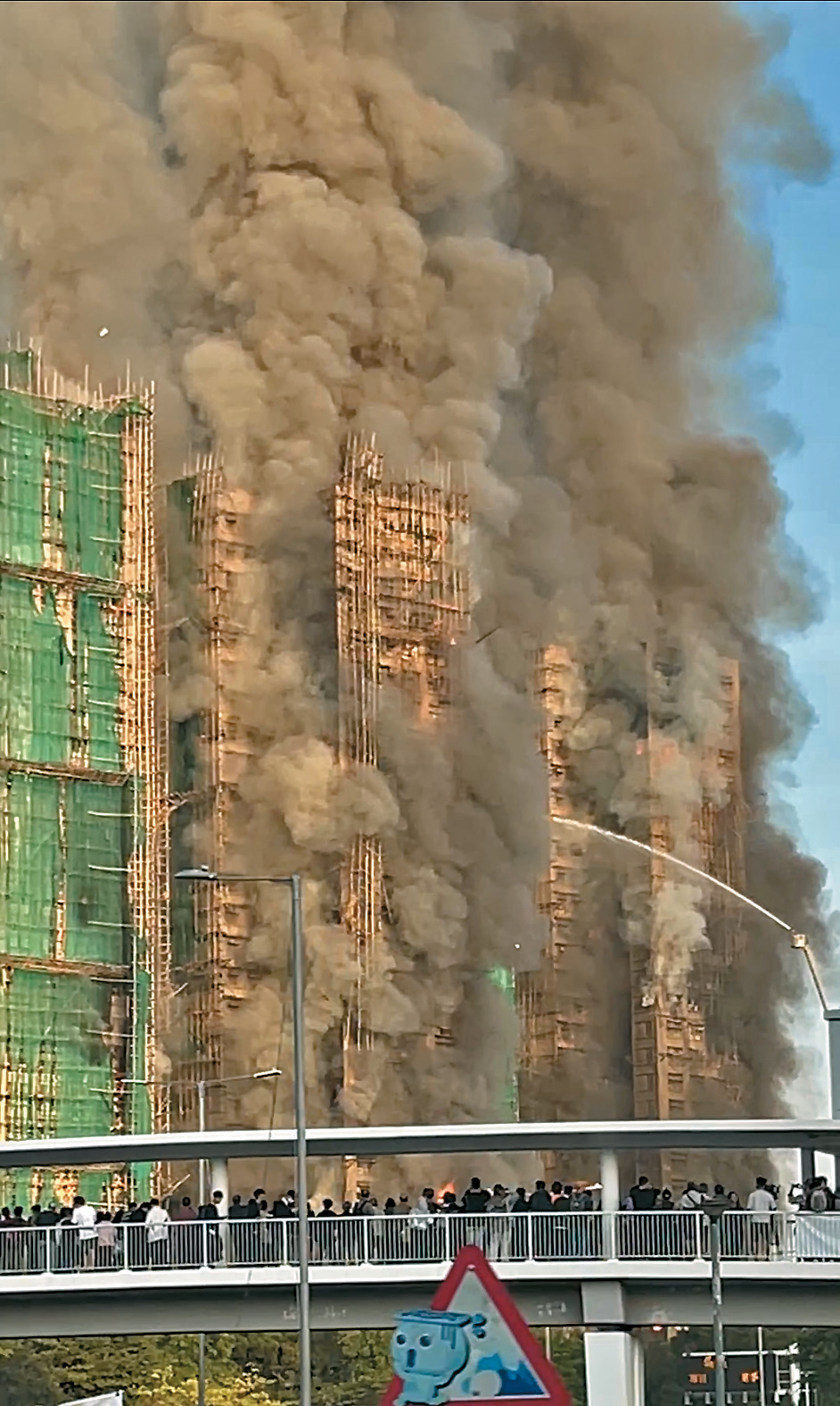 大埔宏福苑发生5级火警，火势猛烈，大批市民聚集在附近天桥了解最新情况。