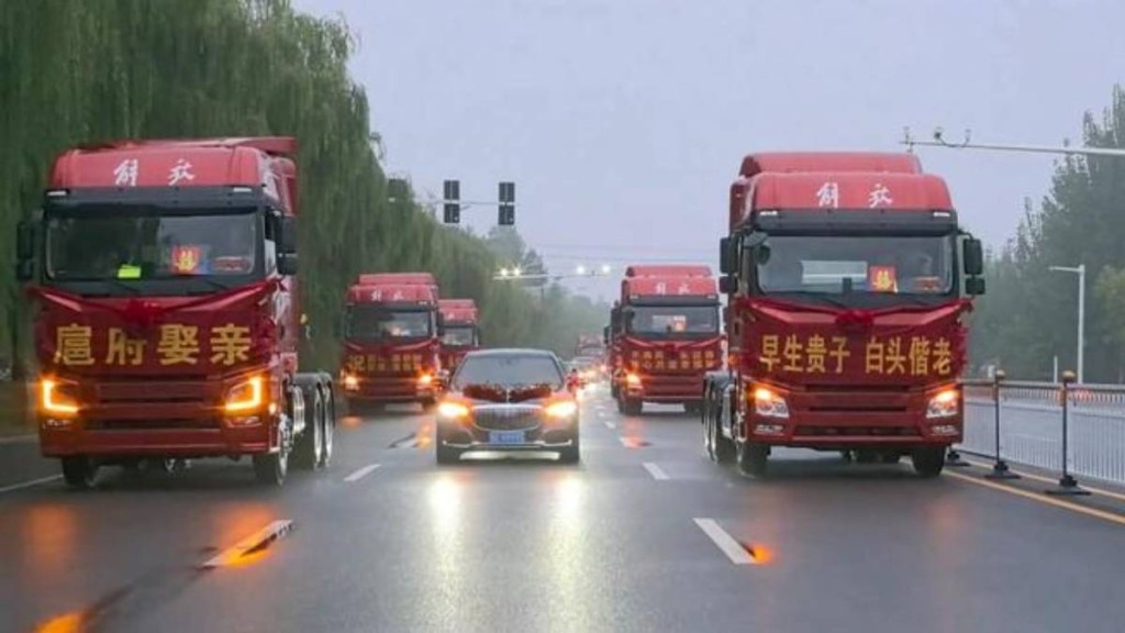 山東一婚禮動用6輛紅色解放牌大卡車組成迎親車隊。極目新聞