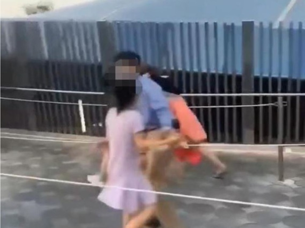 工作人員將女童與兩打架女子分隔開。網圖