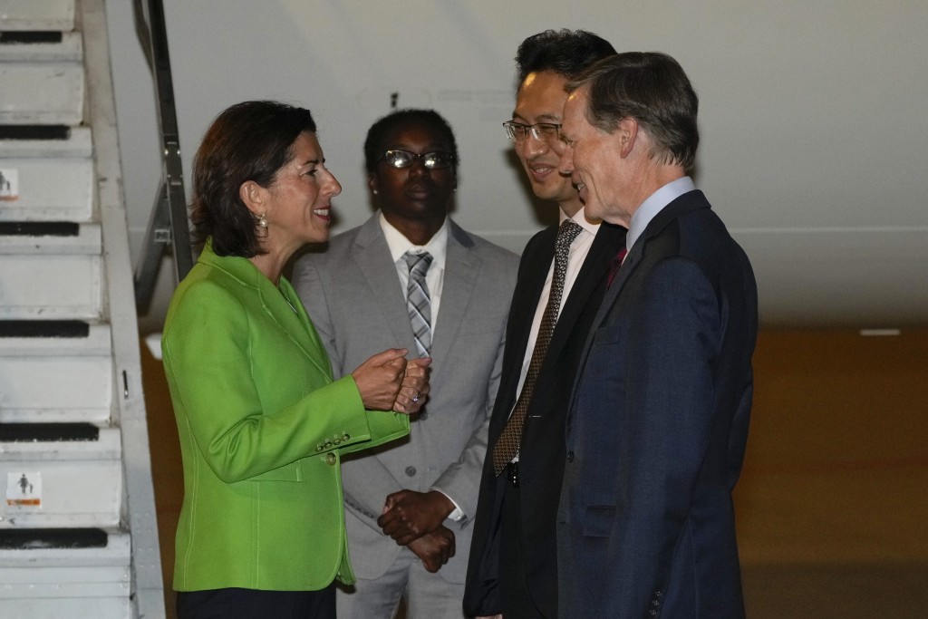美国商务部长雷蒙多昨晚抵达北京首都国际机场后与中国商务部司长林峰（右二）和美国驻华大使伯恩斯（右）交谈。AP