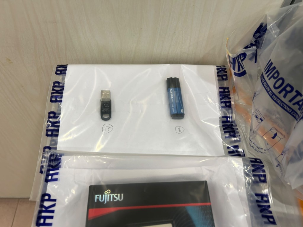 警方從被捕男子的寓所內撿取思疑與案有關的電腦設備。 警方從被捕男子的寓所內撿取思疑與案有關的電腦設備。