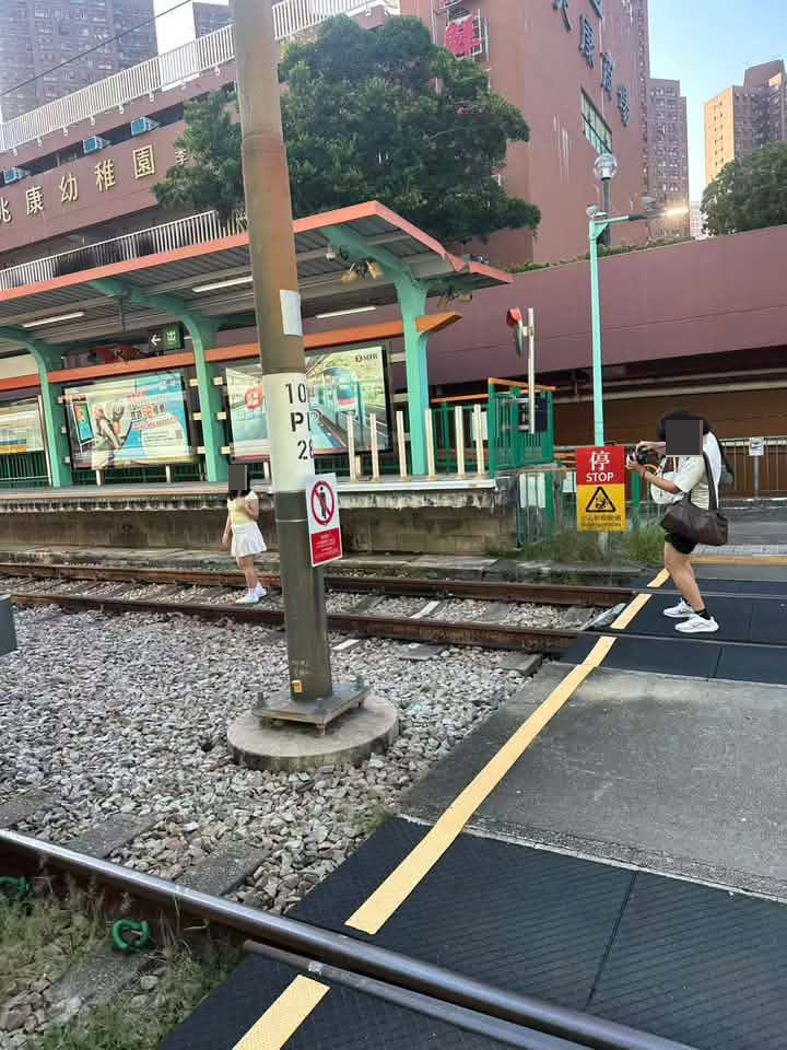 一名身穿短裙的長髮女子闖入輕鐵兆康站的路軌,然後擺姿勢讓同行的朋友為她拍照。網上圖片 一名身穿短裙的長髮女子闖入輕鐵兆康站的路軌,然後擺姿勢讓同行的朋友為她拍照。網上圖片